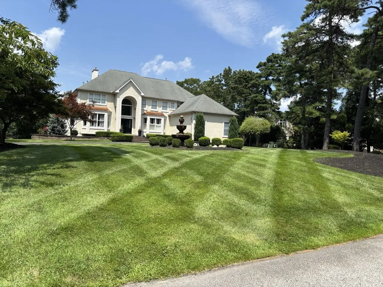 Striped front lawn and landscaped beds at a large home in Marlton (Evesham Township), NJ